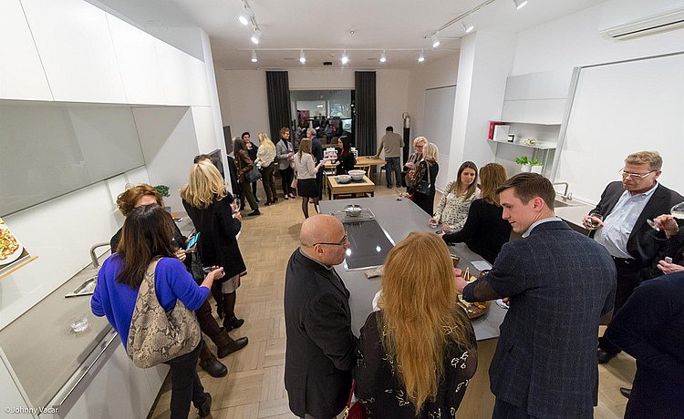 Photo from above, with guests socializing and connecting in our bulthaup b3 kitchen.